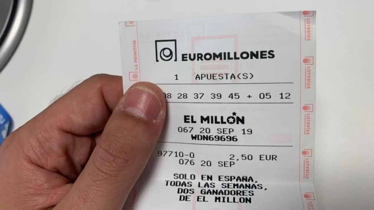 Mano sosteniendo un boleto del Euromillón similar al implicado en un caso de intento de cambiazo.