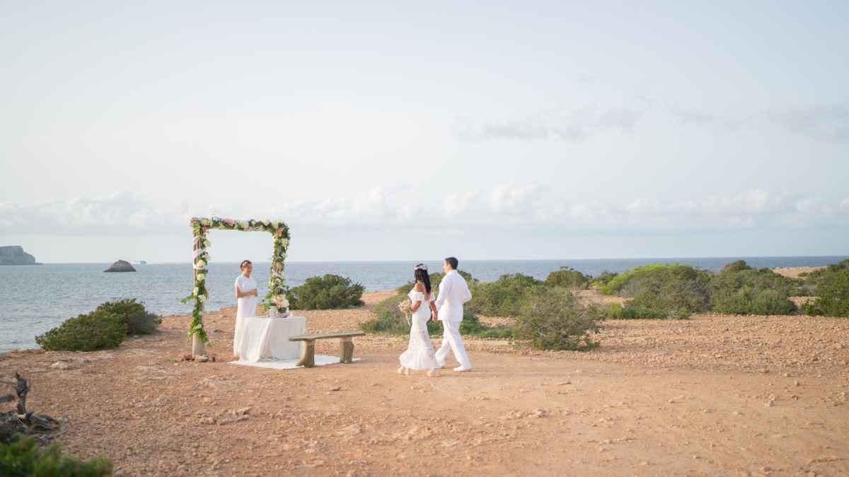Ceremonia de boda en la playa con pareja caminando hacia el altar