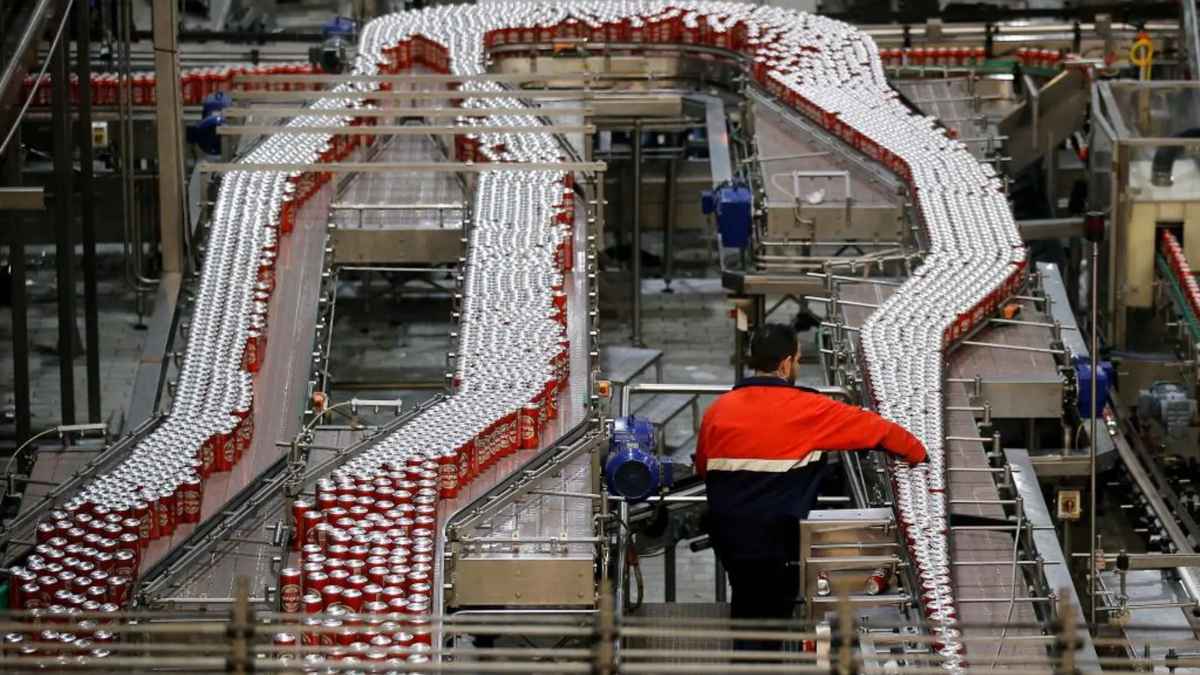 Operario en fábrica de Mahou supervisando la línea de producción de latas de cerveza