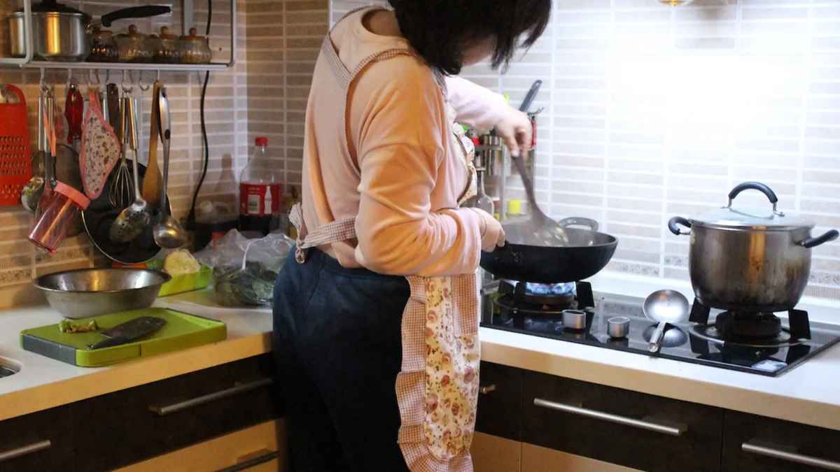 Ama de casa cocinando en la cocina, imagen relacionada con la nueva pensión mensual del Gobierno