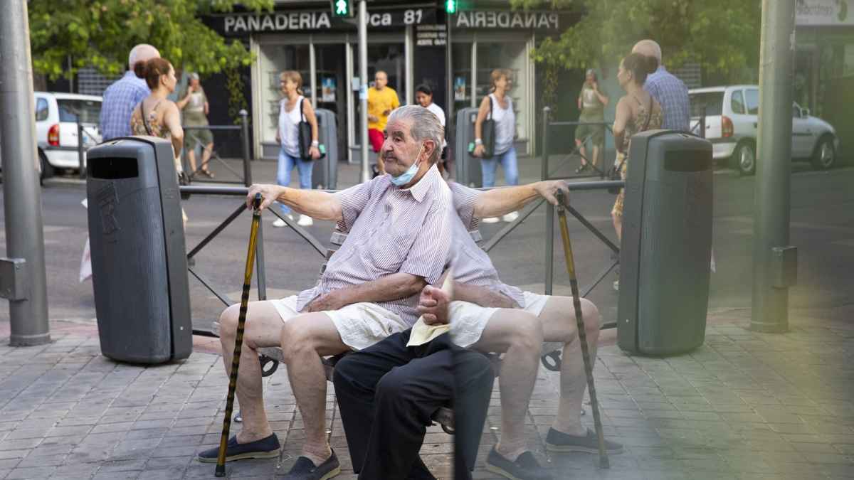 Personas mayores sentadas en un banco en la calle, imagen asociada a las pensiones mínimas y el control de la Seguridad Social.