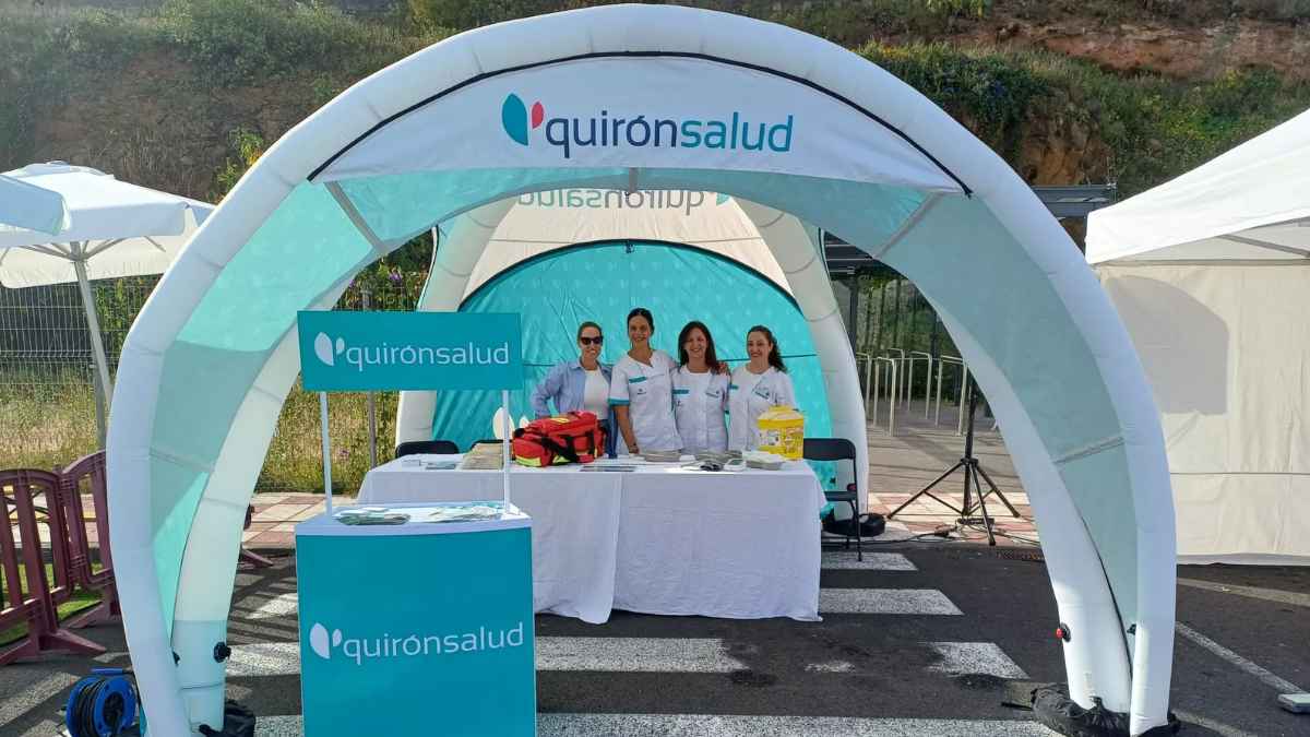 Personal sanitario de Quirónsalud en un stand informativo del grupo hospitalario en España