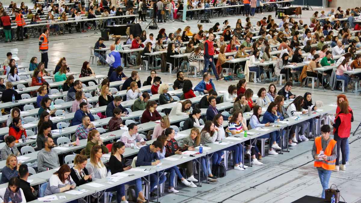 Aspirantes realizando un examen de oposiciones en una sala multitudinaria en Cataluña.