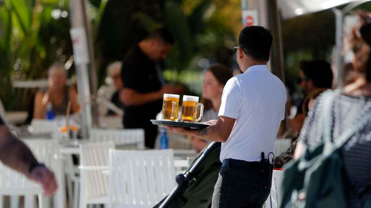 Camarero sirviendo bebidas en la terraza de un restaurante en Madrid