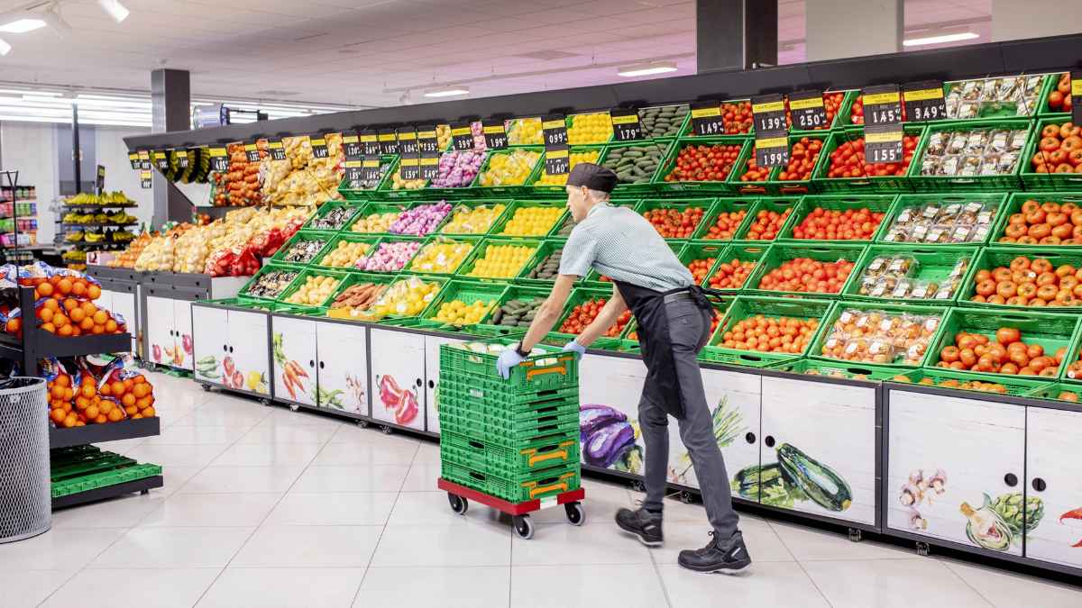 Trabajador supermercado reponiendo fruta jornada laboral fin de semana