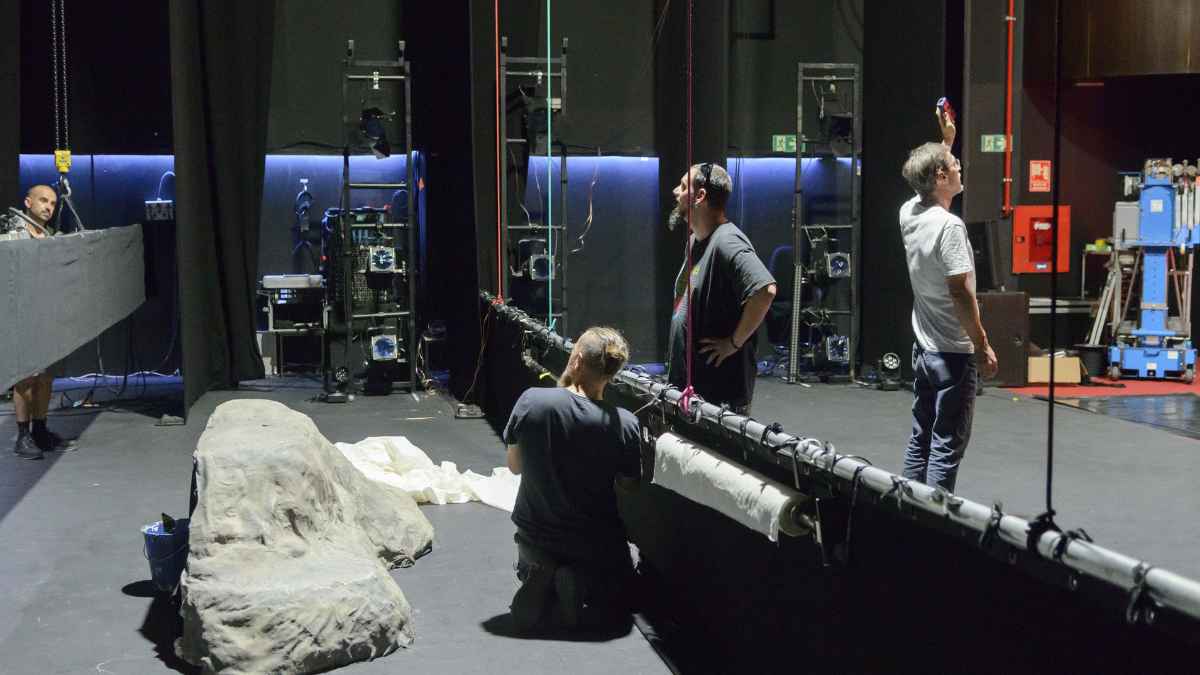 Técnicos y artistas preparando un escenario teatral relacionados con el subsidio de 600 euros del SEPE