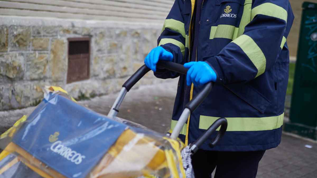 Trabajador de Correos empujando carro de reparto en Toledo por falta de personal