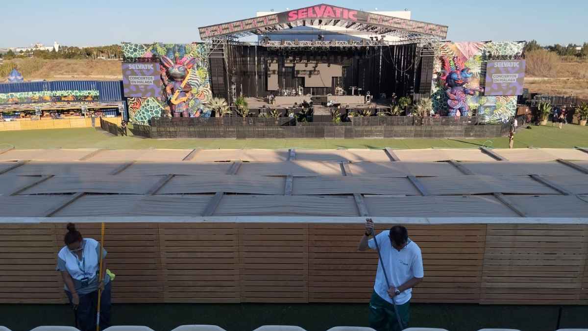 Personal de limpieza preparando un recinto de conciertos al aire libre antes de un evento en Badajoz.
