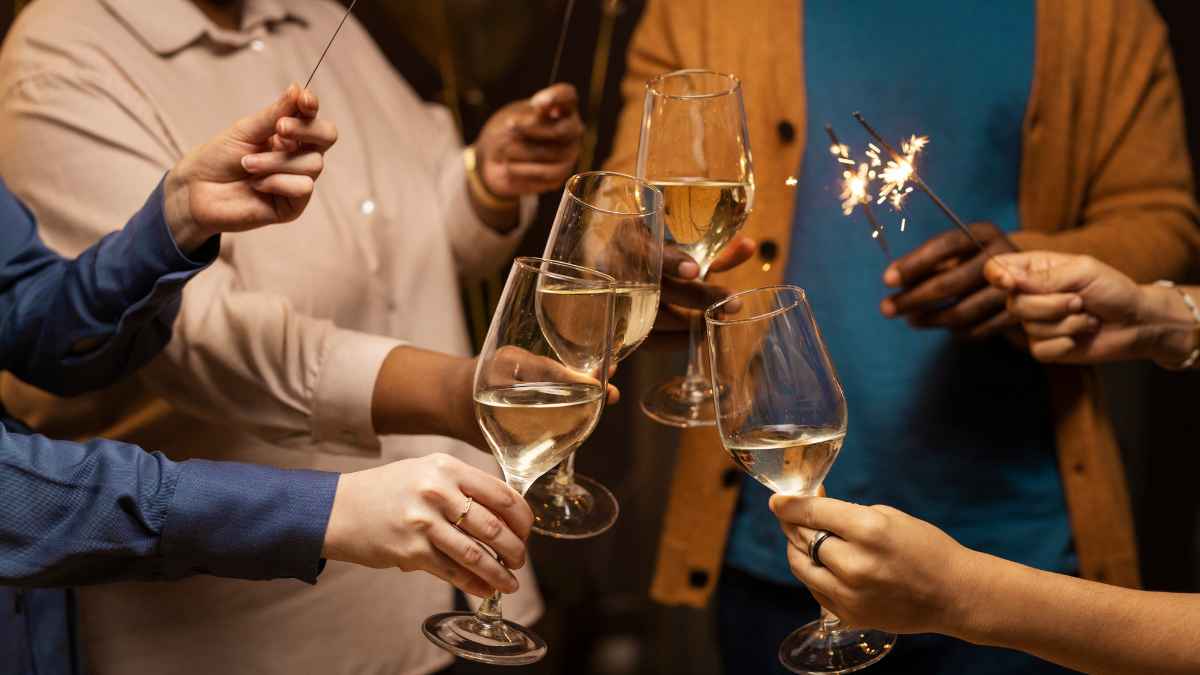 Camarero y compañeros brindando con copas de champán en una celebración de Nochevieja