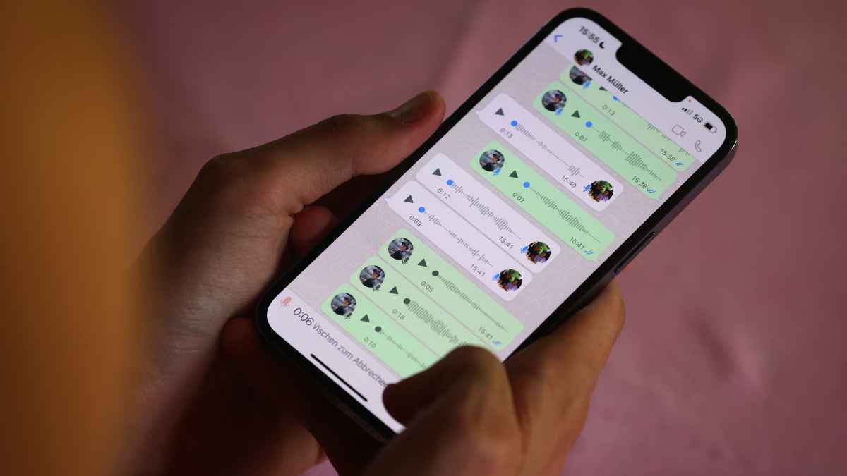Persona usando el móvil para escuchar audios en un chat de WhatsApp.