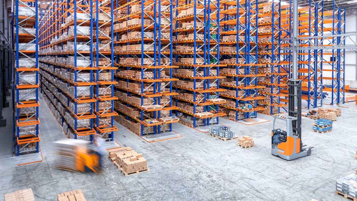 Almacén logístico con estanterías y operarios trabajando en Pinto