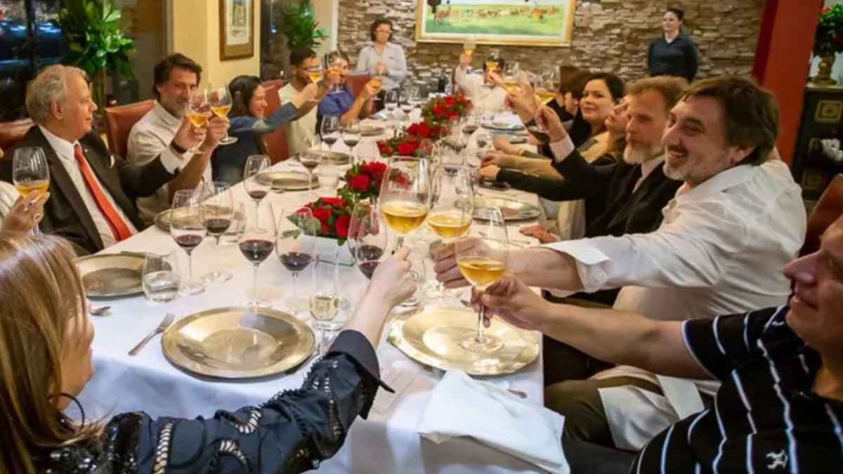Cena de empresa en Navidad con trabajadores brindando durante una comida corporativa