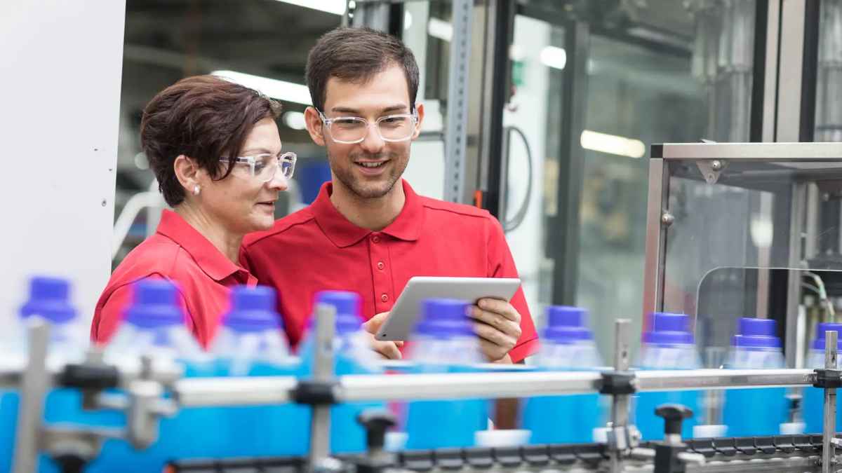 Operarios de fábrica trabajando en una línea de producción en Vilalba, Lugo