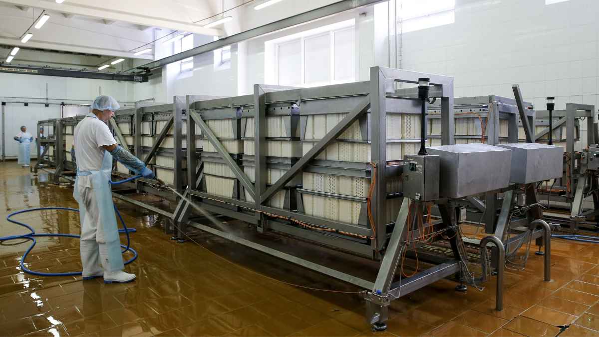 Operarios limpiando maquinaria industrial en una planta alimentaria de Tarancón