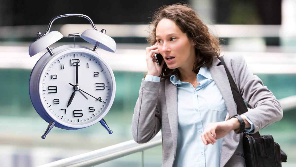 Mujer apresurada mirando la hora junto a un reloj grande, relacionada con un caso de despido por llegar antes al trabajo.