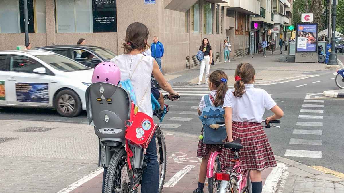 Familia con niños circulando en bicicleta por una calle de Valencia