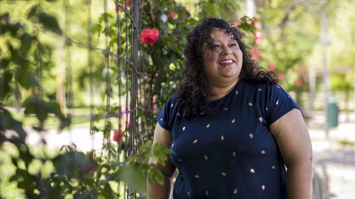 Carolina Elías, cuidadora salvadoreña en España, retratada en un parque durante una entrevista