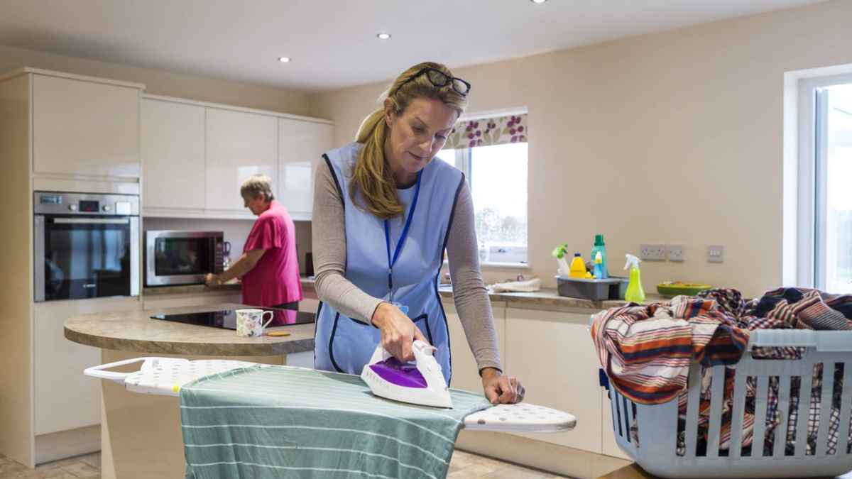 Empleada de hogar realizando tareas domésticas en una vivienda familiar