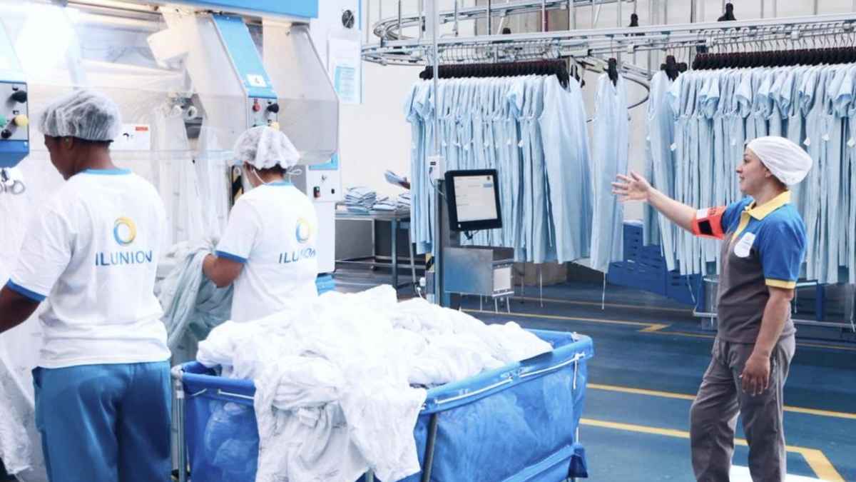 Operarios de Ilunion trabajando en una lavandería industrial en puestos de limpieza y clasificación textil