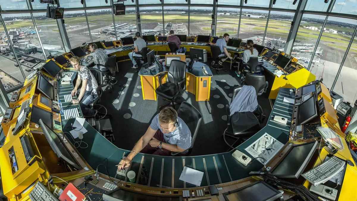 Controladores aéreos trabajando en la torre de control durante la gestión del tráfico aéreo