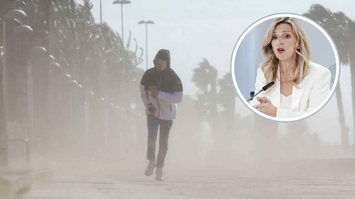 Trabajador caminando con viento y lluvia por alerta meteorológica mientras Trabajo recuerda el permiso climático retribuido