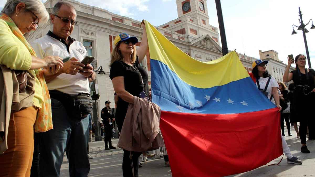 Trabajadores venezolanos en España con bandera de Venezuela durante una concentración en Madrid