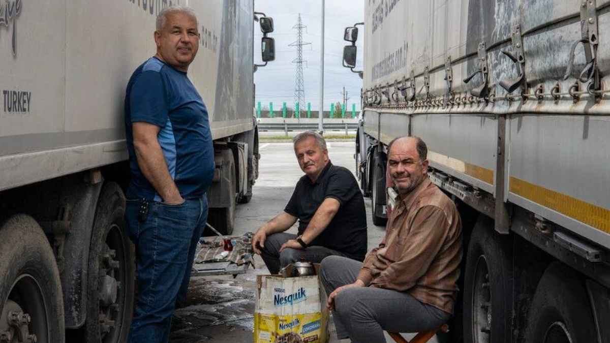 Camioneros turcos descansan junto a camiones de transporte en una ruta internacional hacia España
