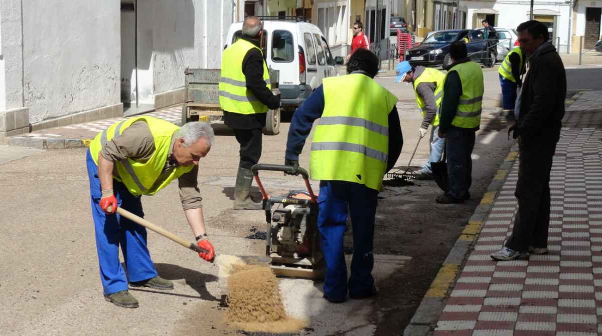 Operarios realizando trabajos de mantenimiento como Peón del Ayuntamiento de Sevilla en la vía pública