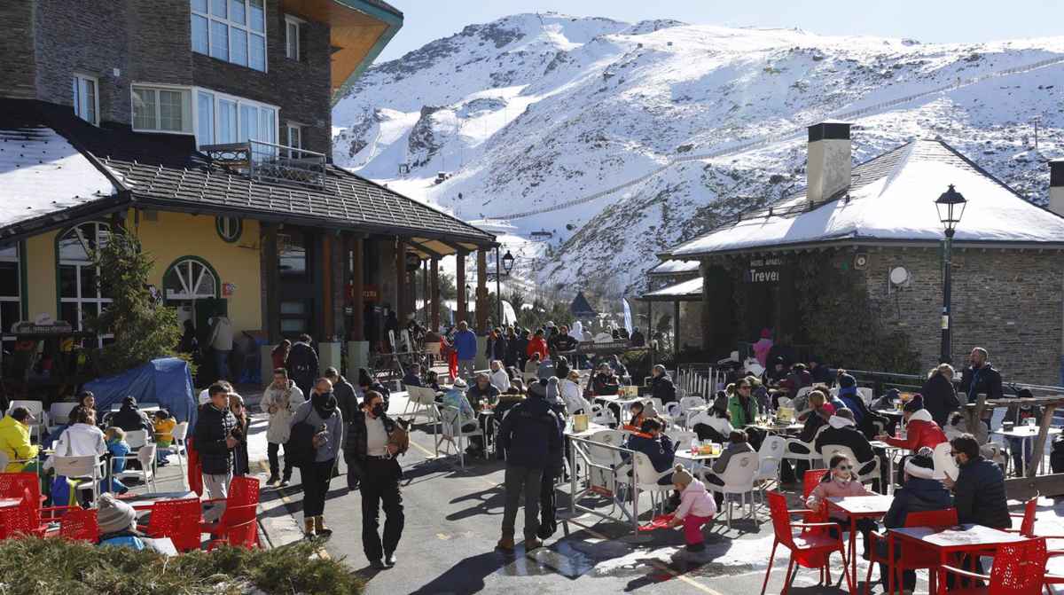 Estación de Sierra Nevada con visitantes en zona de restauración y nieve en temporada de invierno