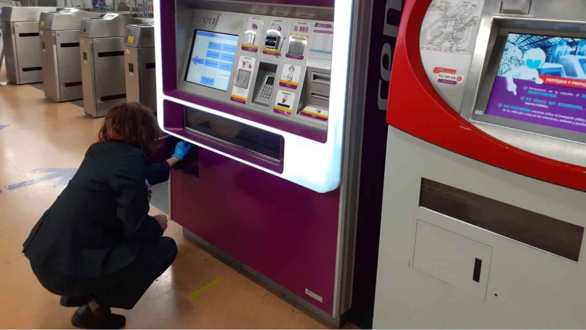 Empleado de Renfe manipulando una máquina de autoventa de billetes en una estación