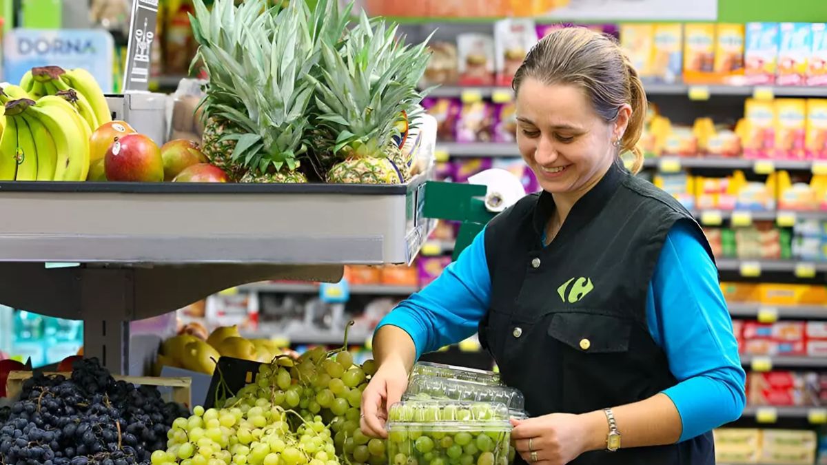 Trabajadora de Carrefour en sección de productos frescos durante campaña de empleo en supermercados