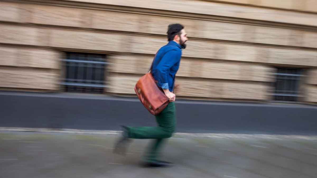 Trabajador llegando tarde al trabajo tras perder el plus de presencia de 9 euros diarios