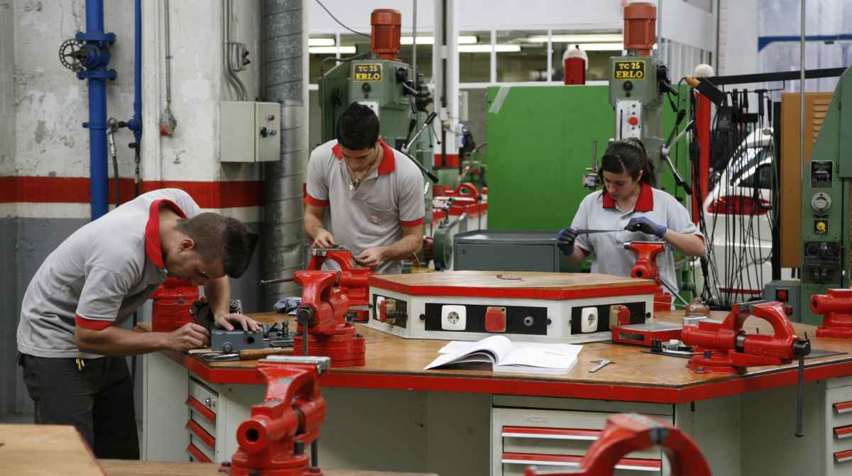 Estudiantes de Formación Profesional trabajando en un taller industrial con maquinaria técnica