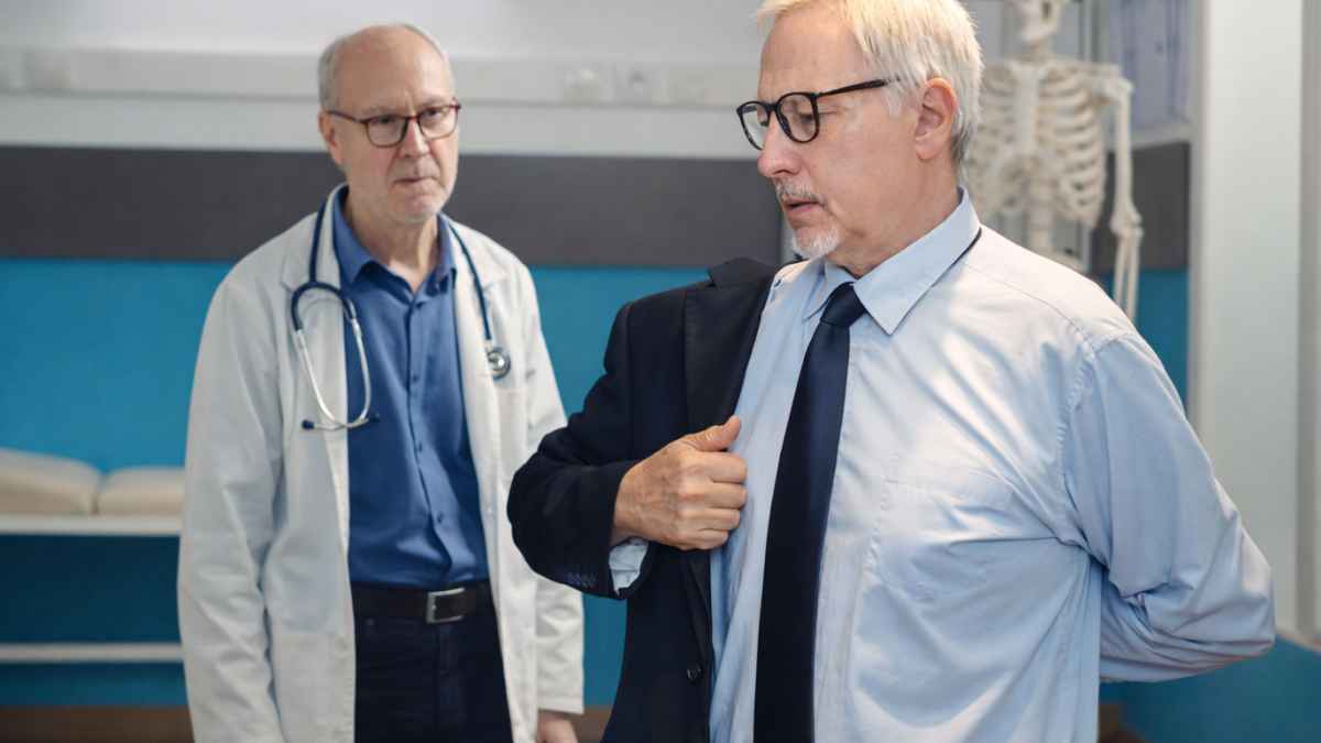 Tribunal médico observando a un hombre mientras se pone el abrigo durante una evaluación de incapacidad permanente