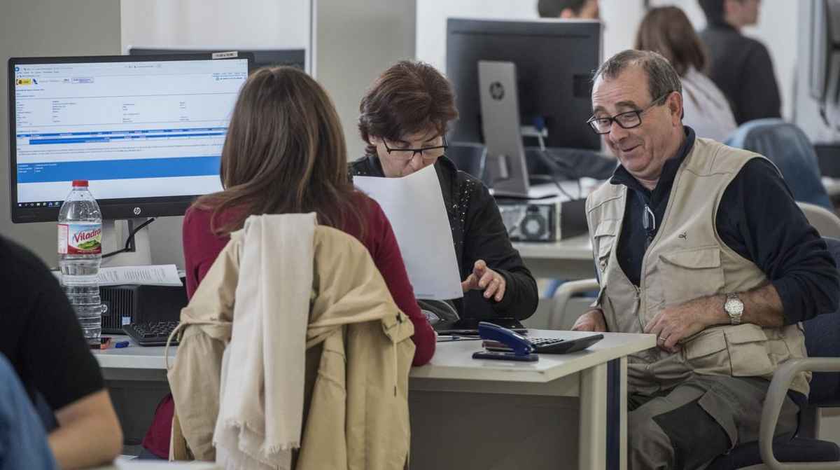 Jubilados realizando trámites de la declaración de la Renta para aplicar la deducción del 75% del seguro colectivo en el IRPF