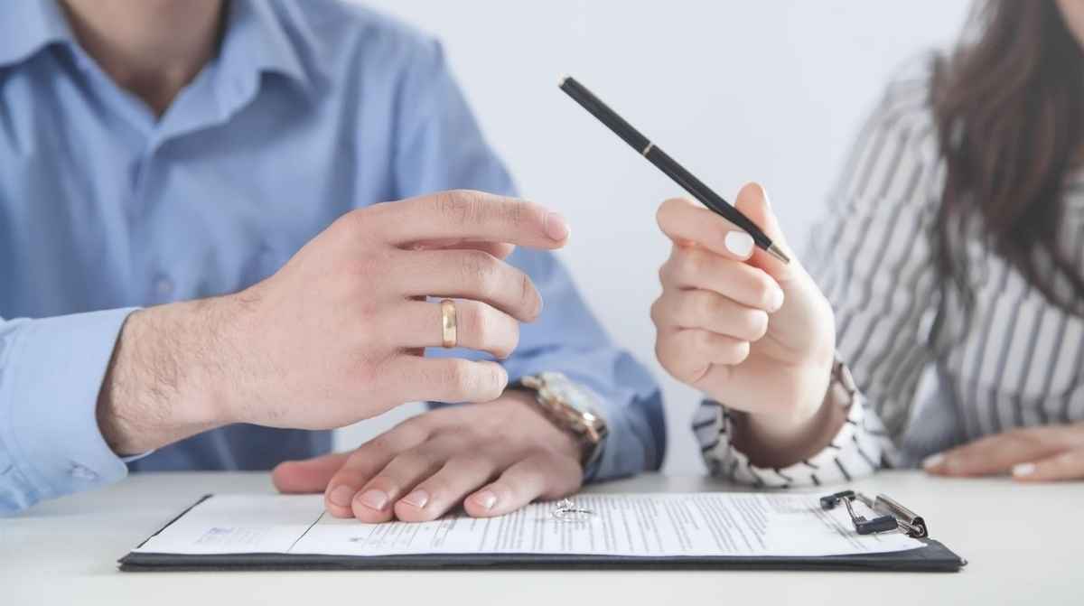 Pareja firmando documentos para hacerse pareja de hecho y solicitar 15 días de permiso laboral