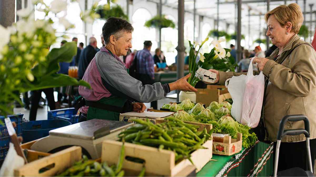 Agricultora vendiendo productos en un mercado tras la sentencia que obliga a un concejo vasco a devolverle sus tierras