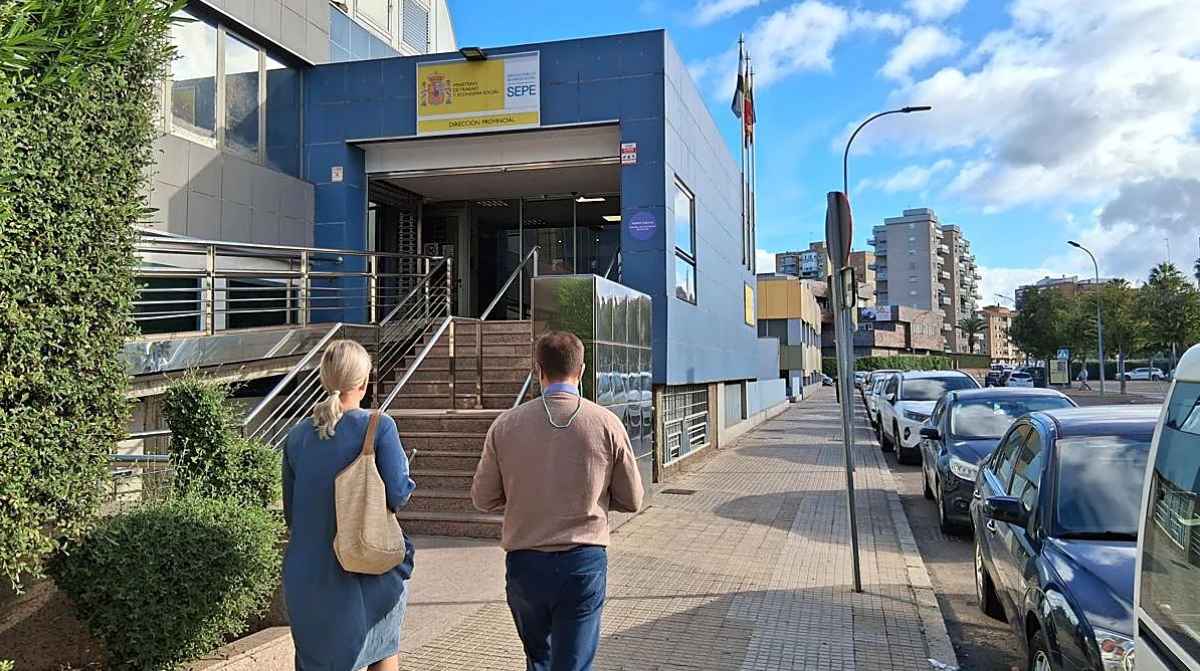 Oficina del SEPE con dos personas entrando para gestionar el subsidio por desempleo