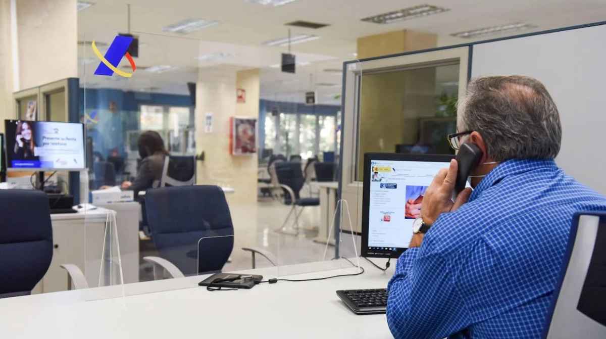 Funcionario atendiendo en oficina pública tras los cambios en la ley que permite el despido con pérdida de plaza