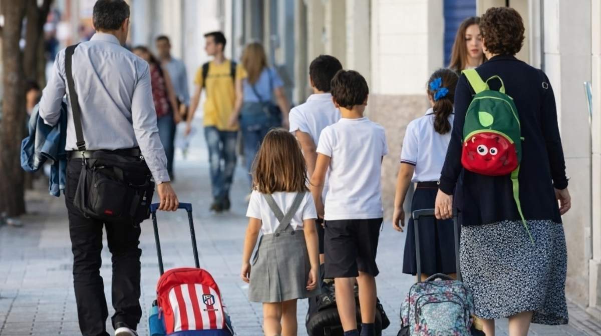 Padres llevando a sus hijos al colegio mientras conciliación laboral permite adaptar la jornada de trabajo