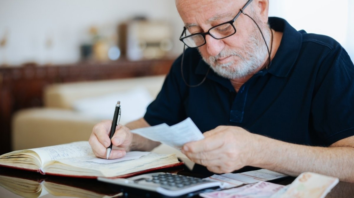 Jubilado revisando cuentas y documentos tras un fallo en el complemento de pensión