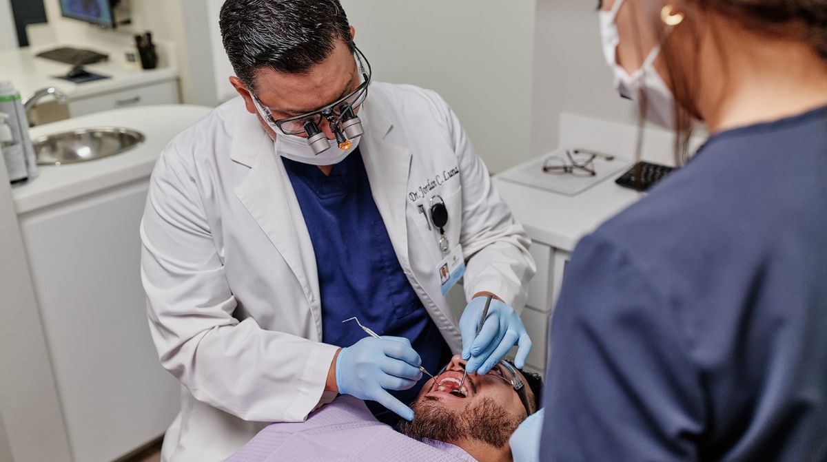 Dentista realizando tratamiento dental a paciente para deducciones de gastos en la Renta