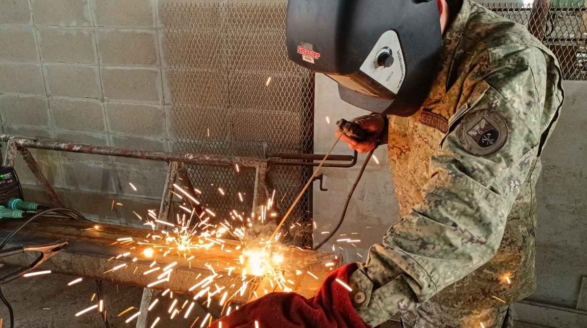 Soldador trabajando en una pieza metálica en la industria de defensa ante la creciente demanda de trabajadores cualificados en Europa