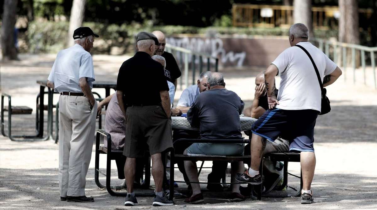 Grupo de hombres jubilados reunidos en un parque tras sentencia del Supremo sobre complemento de pensión