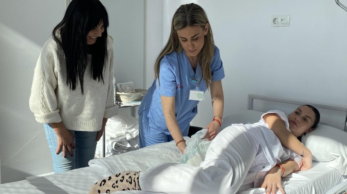 Mujer cuidando a familiar hospitalizado con asistencia sanitaria durante permiso laboral