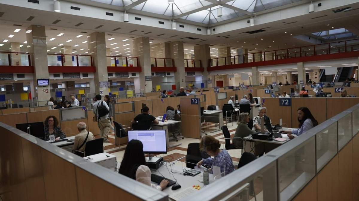 Funcionarios atendiendo en oficina pública tras sentencia del Supremo sobre funciones superiores y ascenso