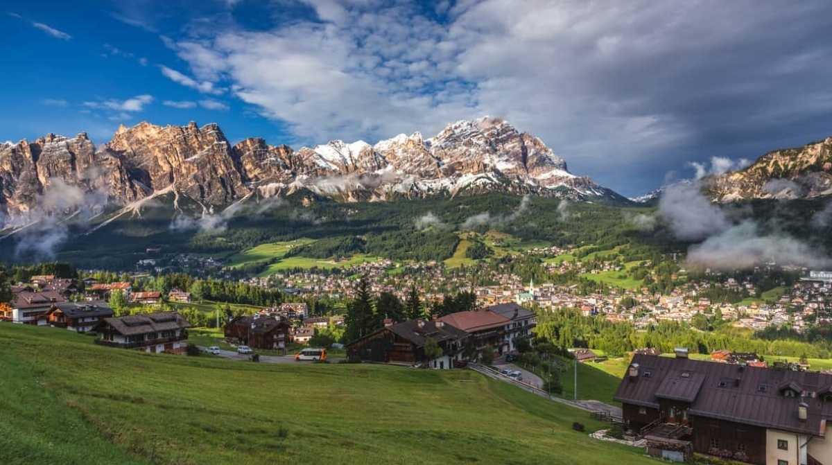 Paisaje de los Alpes italianos con pueblo de montaña donde buscan voluntarios para experimento remunerado