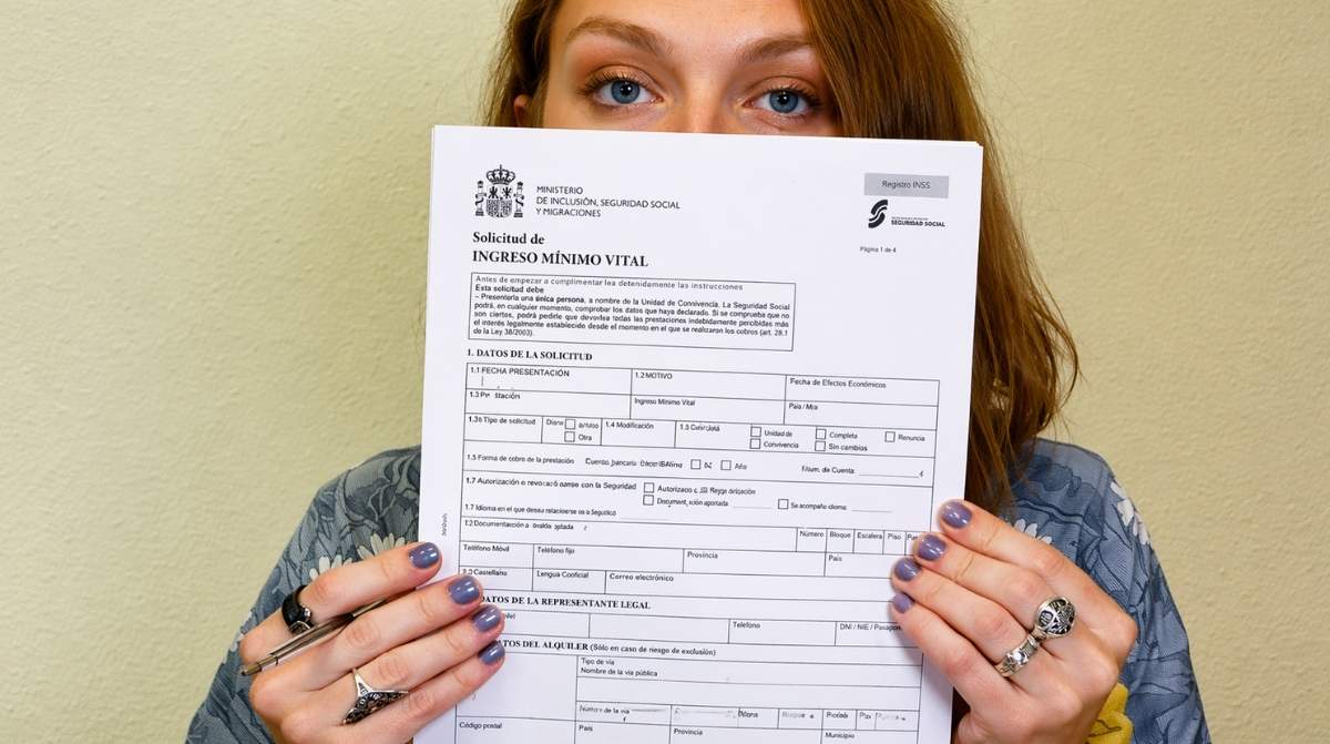 Mujer mostrando solicitud del Ingreso Mínimo Vital tras resolución judicial favorable frente a la Seguridad Social