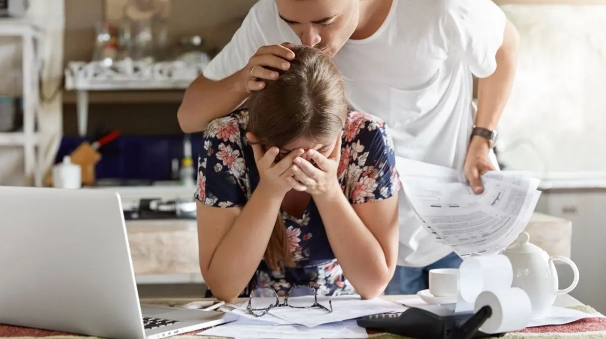 Madre preocupada revisando facturas tras reclamación del IMV por error del INSS