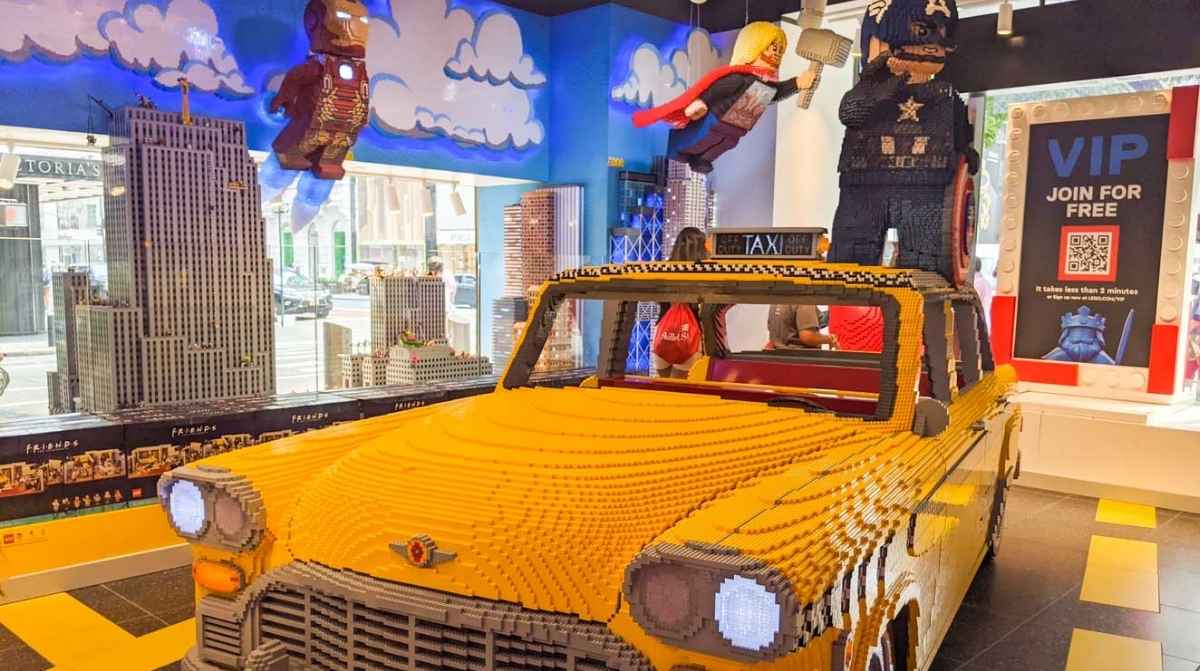 Interior de tienda LEGO con figuras y coche construido con piezas en nueva apertura en Murcia